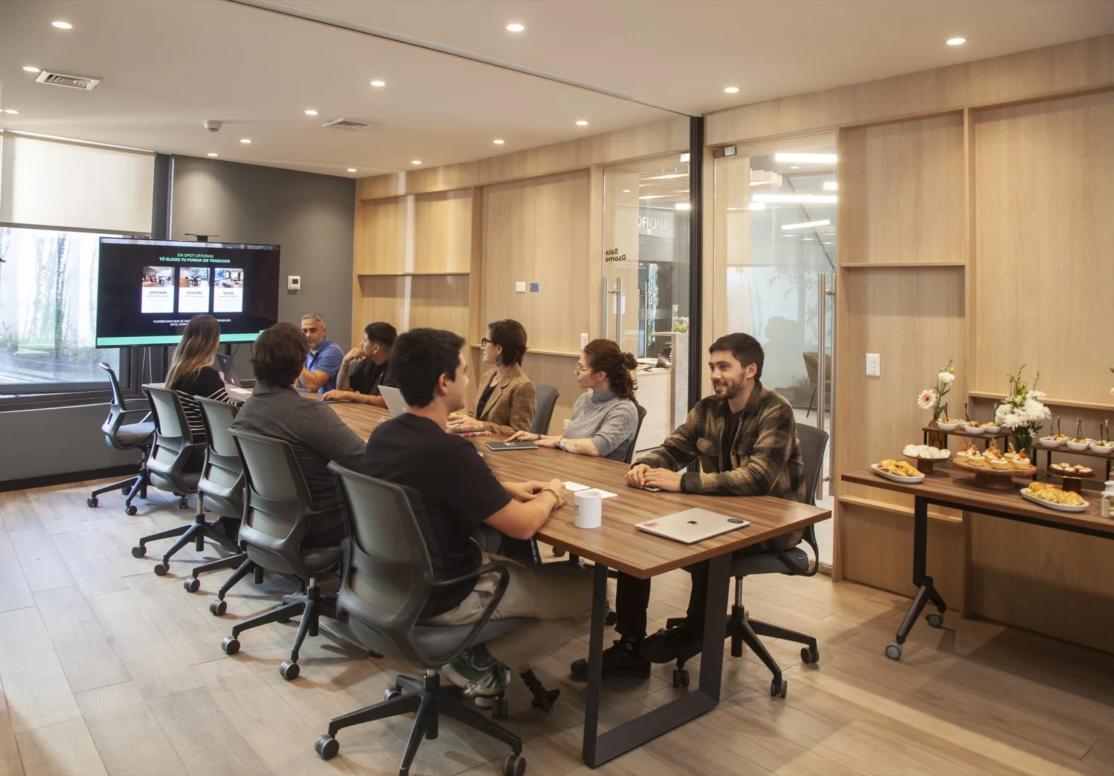 Sala de directorio en uso, con pantalla y catering