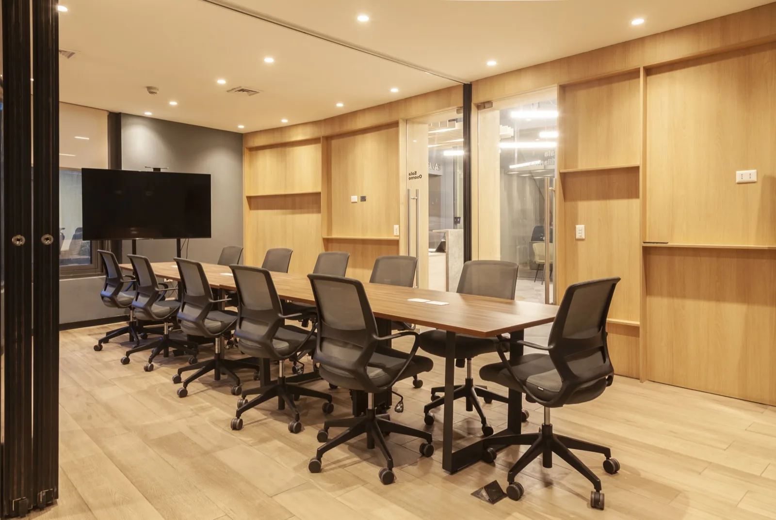 Sala de directorio con revestimiento de madera y pantalla